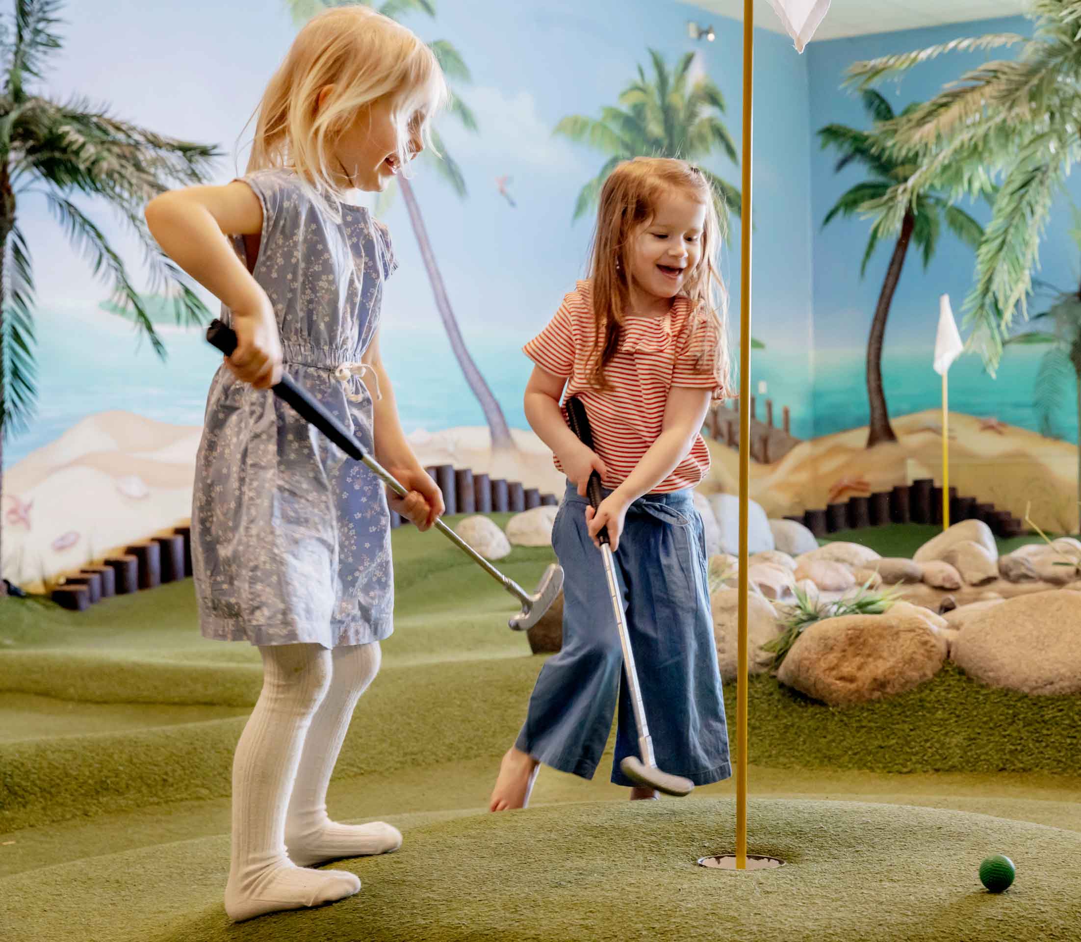 Två flickor spelar äventyrsminigolf på Pite havsbad
