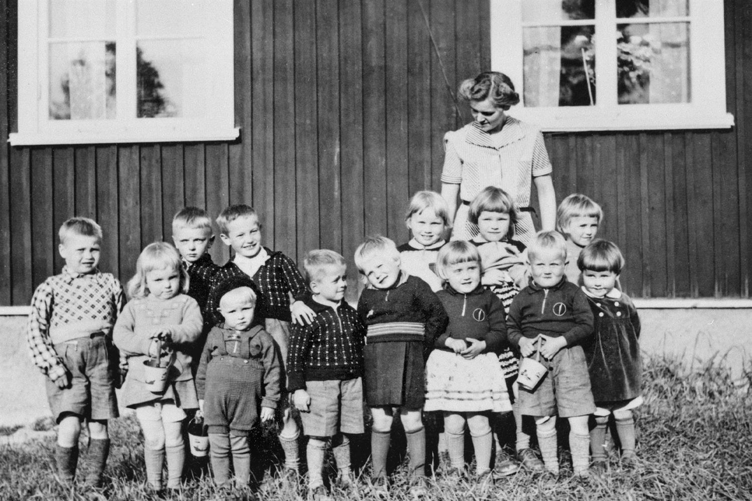 Karin Palo framför lärarbostaden i Gamla Falmark, tillsammans med finska flyktingbarn 1942